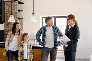 Husband, wife and son meeting with a realtor inside a home.