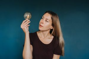 A woman looking at a lightbulb - original idea